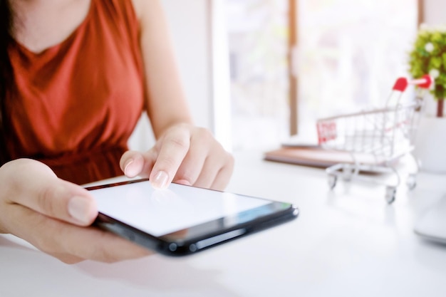 Section médiane d'une femme utilisant un téléphone portable sur la table