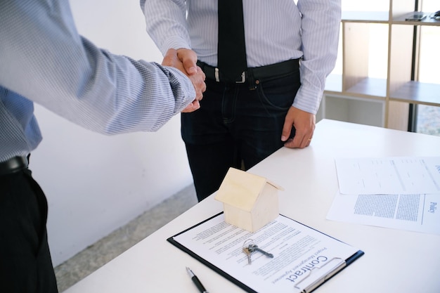 Une section médiane de gens d'affaires se serrant la main en travaillant au bureau.