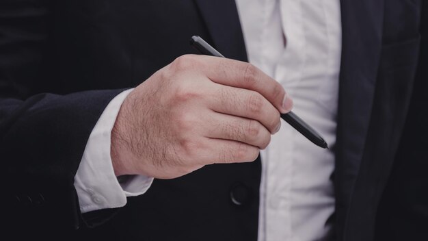 Section médiane d'un homme d'affaires tenant un stylo