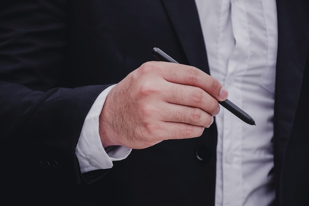 Section médiane d'un homme d'affaires tenant un stylo