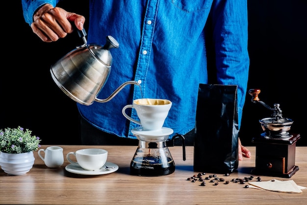 Section médiane d'un homme faisant du café sur une table en bois