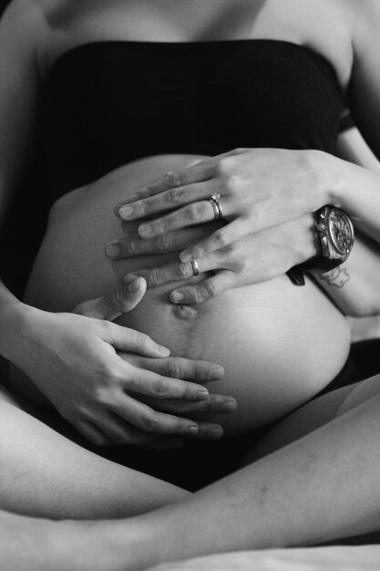 Photo section médiane d'un homme et d'une femme touchant l'abdomen d'une enceinte