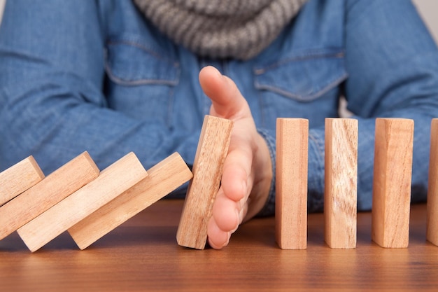 Section médiane d'un homme jouant avec des dominos en bois sur une table en bois