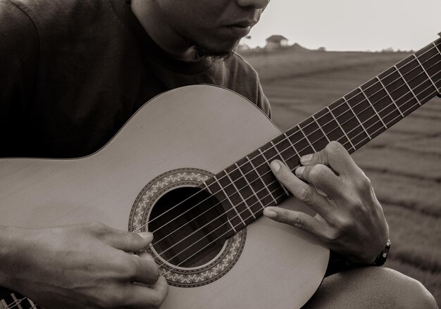 Section médiane d'un homme jouant de la guitare à l'extérieur