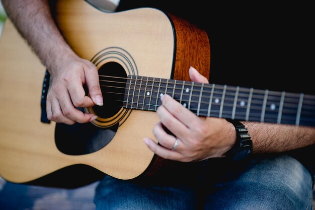 Photo section médiane d'un homme jouant de la guitare à l'extérieur