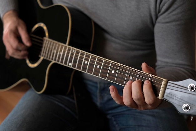 Section médiane d'un homme jouant de la guitare