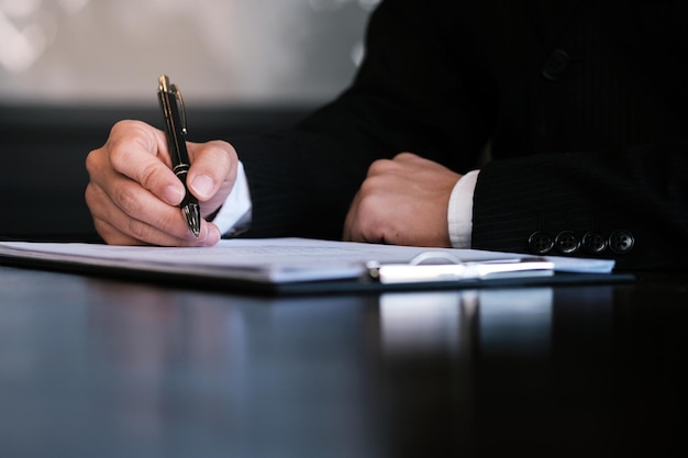 Section médiane d'un homme lisant un livre sur une table