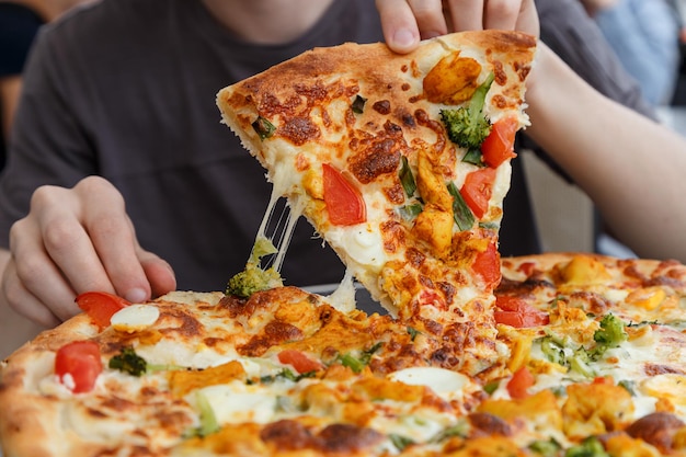 Section médiane d'un homme avec une pizza à la table