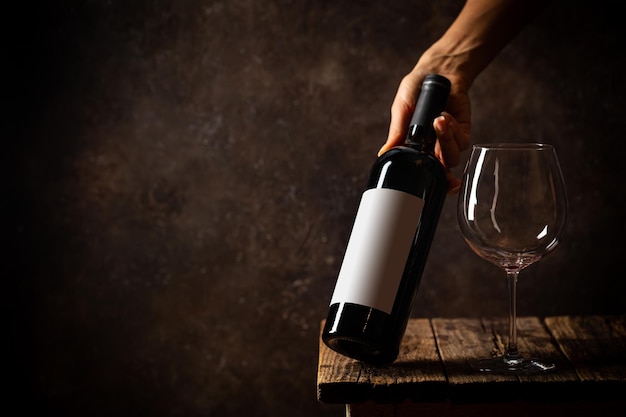 Section médiane d'un homme tenant une bouteille de verre sur la table