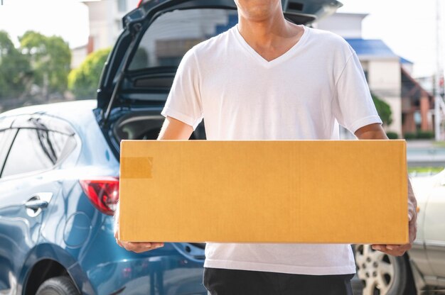 Photo la section médiane de l'homme tenant la caméra alors qu'il se tient près de la voiture