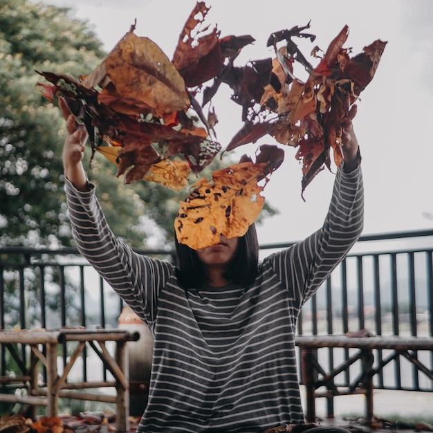 Photo section médiane d'un homme tenant des feuilles d'automne