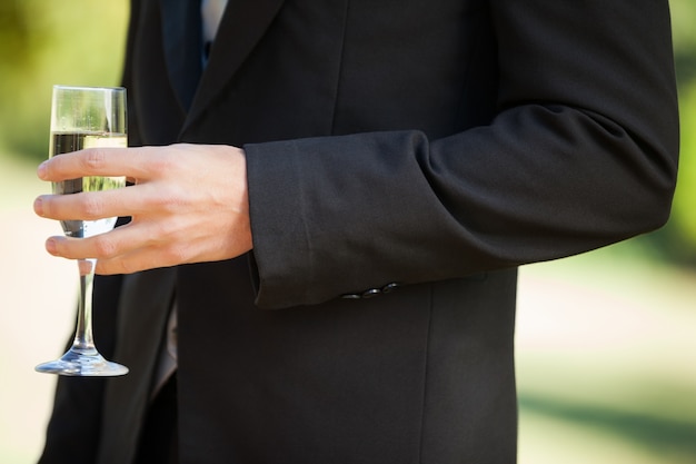 Section médiane d&#39;un homme tenant un verre de champagne au parc