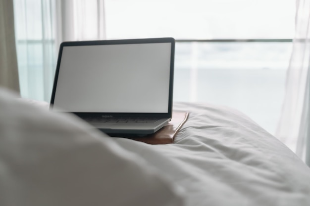 Section médiane d'un homme utilisant un ordinateur portable sur le lit