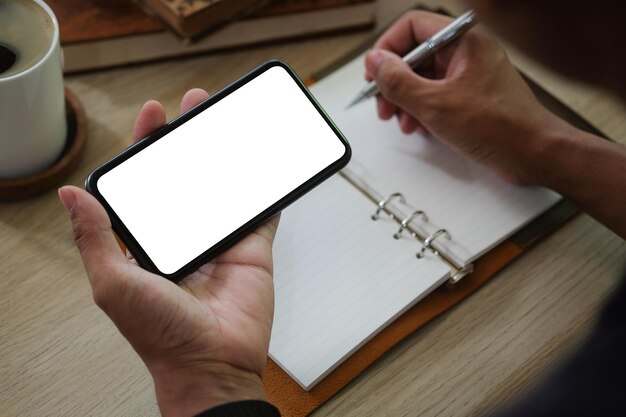 Section médiane d'un homme utilisant un téléphone portable sur une table
