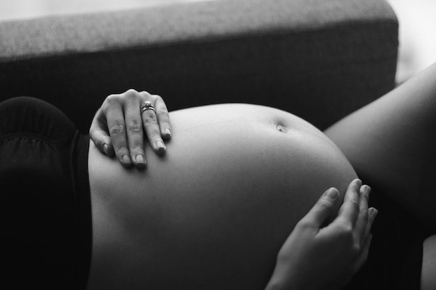 Photo section médiane de la main d'une femme enceinte sur l'abdomen