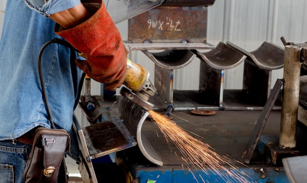 Photo section médiane d'un ouvrier manuel travaillant sur une structure métallique dans une usine