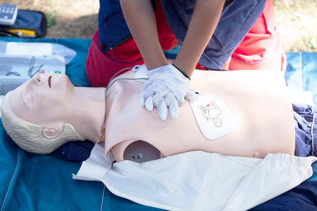 Photo section médiane de la personne appliquant la cpr au mannequin à l'extérieur