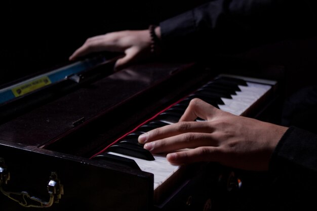 Photo section médiane d'une personne jouant de l'harmonium de piano