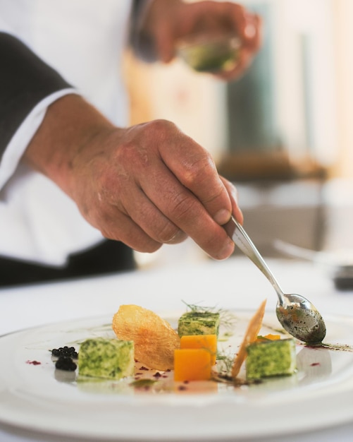 Photo section médiane d'une personne préparant de la nourriture dans une assiette