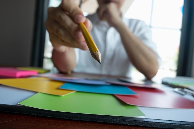 Photo section médiane d'un professionnel de la conception avec un crayon choisissant la couleur au bureau