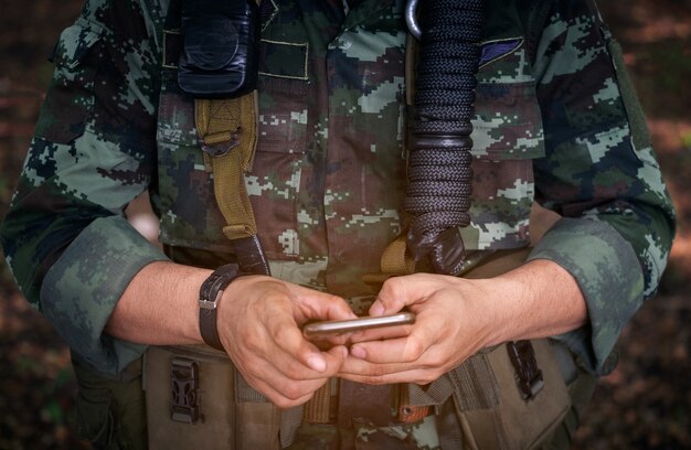 Section médiane d&#39;un soldat militaire utilisant un téléphone portable dans la guerre des camps d&#39;initiation.