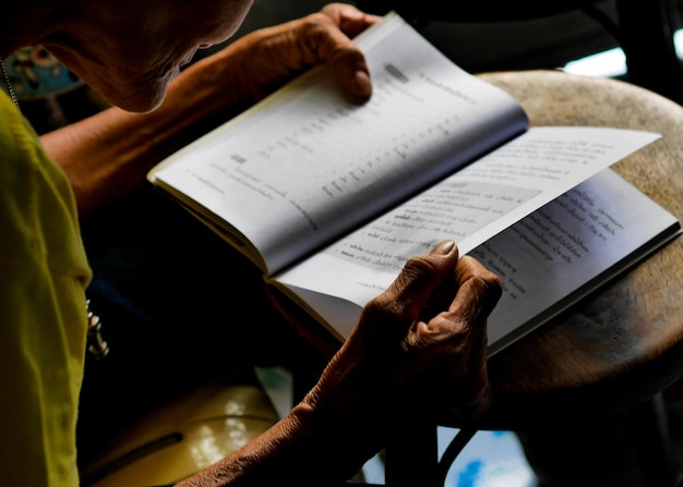 Photo section moyenne d'une femme âgée lisant un livre à la maison