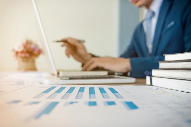 Section moyenne d'un homme d'affaires utilisant un ordinateur portable alors qu'il travaille au bureau