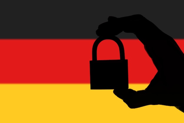 Sécurité Allemagne Silhouette de main tenant un cadenas sur le drapeau national