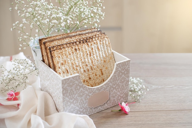 Seder Pessa'h concept de célébration de la Pâque juive Matzah dans une boîte spéciale avec une inscription matzo fleur fuchsia sur la table de la cuisine