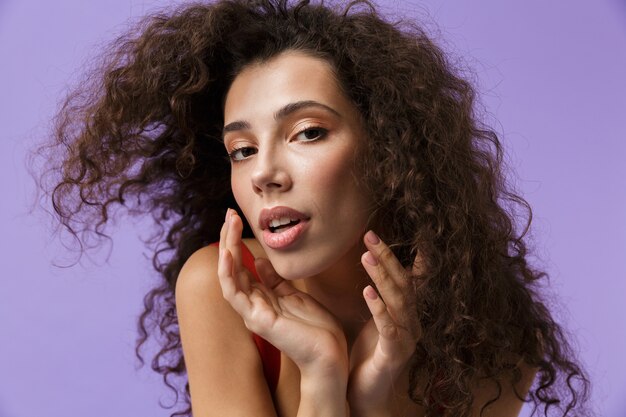 séduisante, femme, porter, robe rouge, sourire, debout, isolé, sur, mur violet