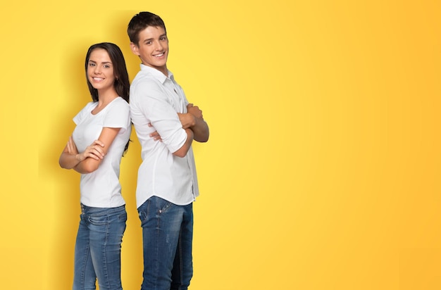 Séduisante jeune couple asiatique souriante étant heureuse et étonnée isolée sur fond de studio jaune