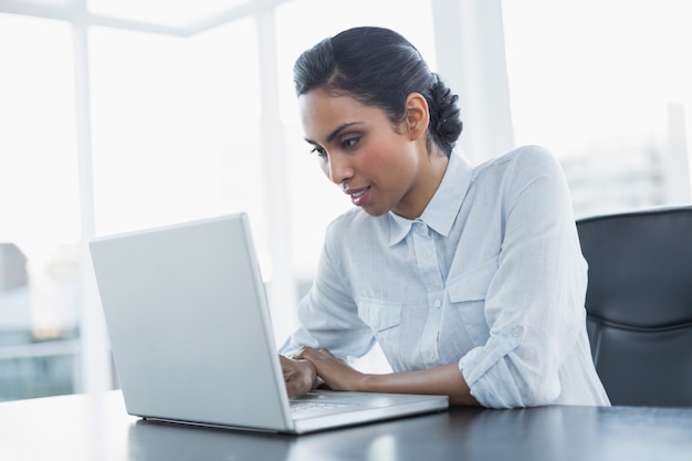 Séduisante jeune femme d&#39;affaires travaillant avec son ordinateur portable