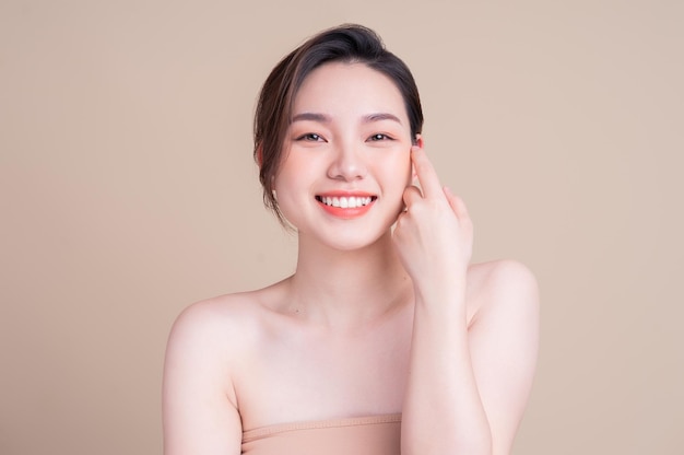 Séduisante jeune femme asiatique à la peau fraîche Soins du visage soin du visage femme beauté peau isolée sur fond blanc cosmétologie beauté peau et concept cosmétique