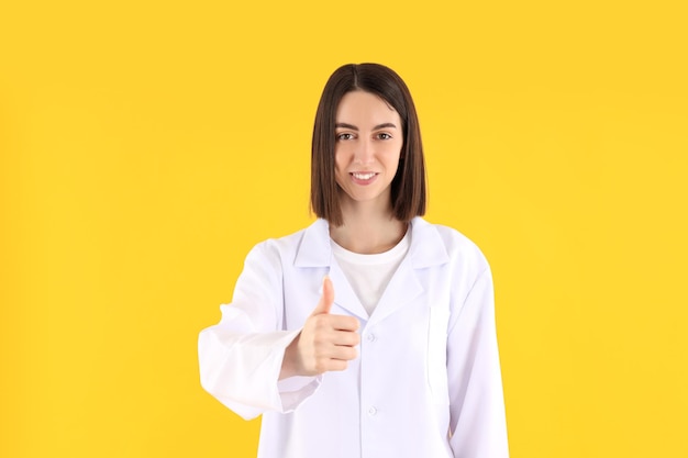 Séduisante jeune femme médecin sur fond jaune