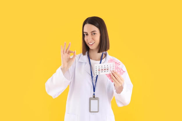 Séduisante jeune femme médecin sur fond jaune