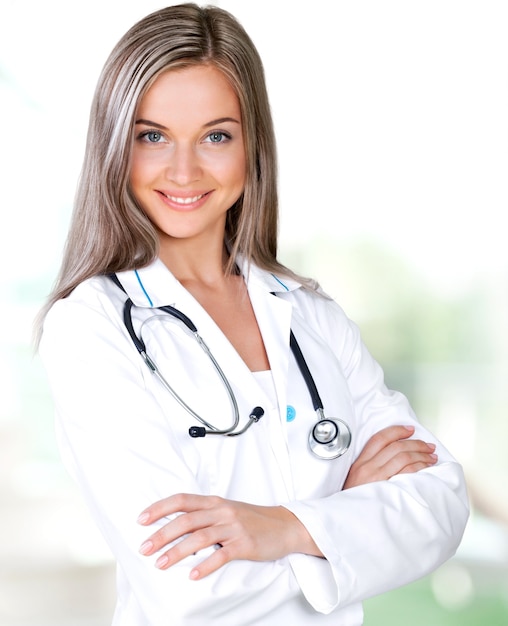 Séduisante jeune femme médecin avec intérieur flou de l'hôpital sur fond