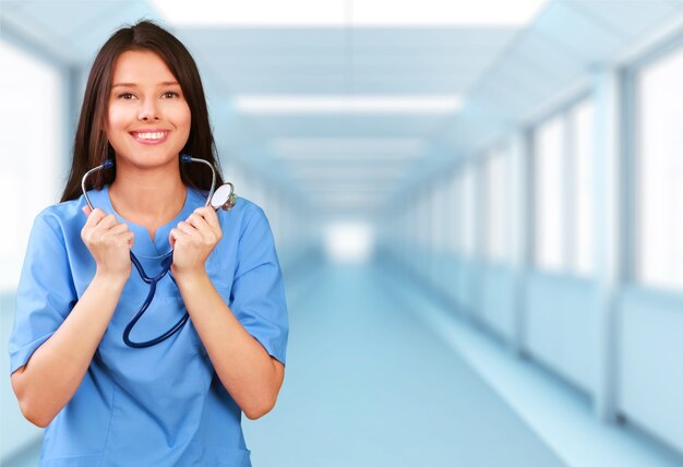 Séduisante jeune femme médecin avec intérieur flou de l'hôpital sur fond