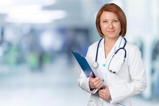 Séduisante jeune femme médecin avec intérieur flou de l'hôpital sur le fond