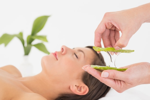 Séduisante jeune femme recevant un massage à l&#39;aloe vera au centre de spa