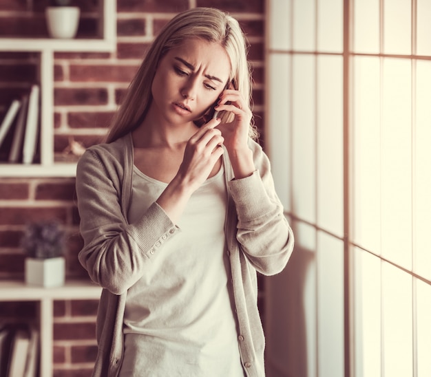 Séduisante jeune fille parle au téléphone.