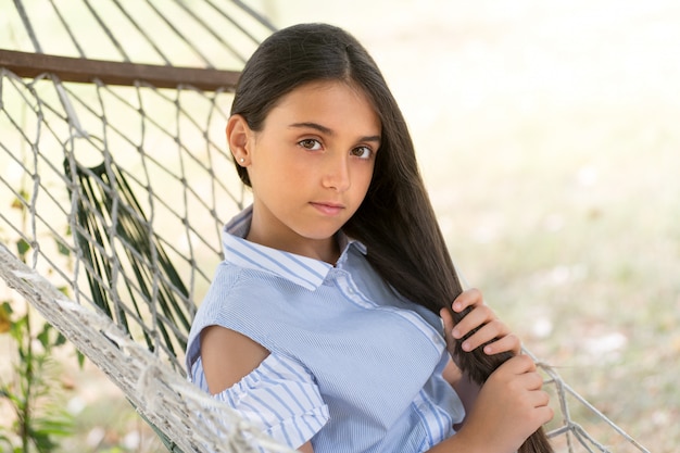 Séduisante jeune fille sérieuse aux longs cheveux noirs