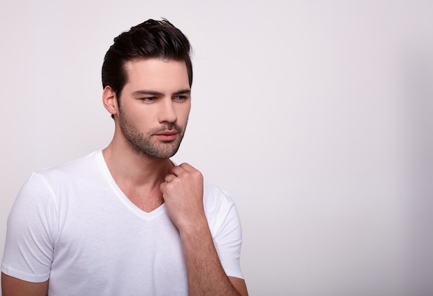 Séduisante jeune homme dans un T-shirt blanc sur un blanc.