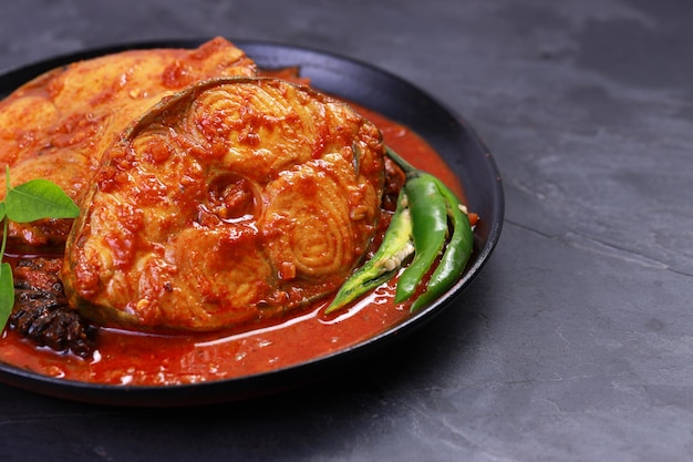 Seer Fish curry Curry de poisson indien disposé dans un bol noir garni de tamarin de malabar