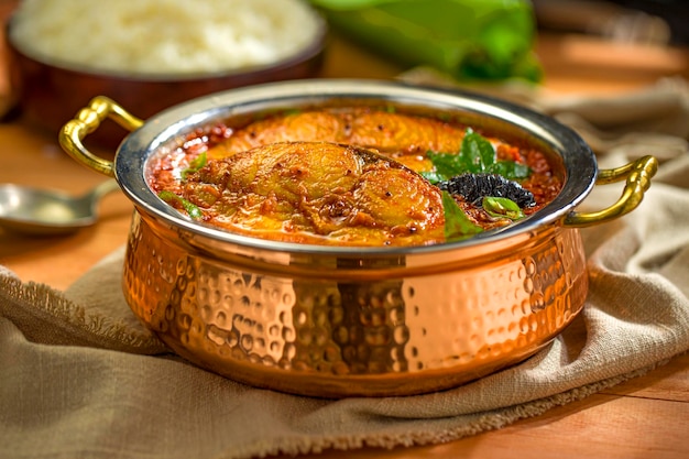 Photo seer fish curry curry de poisson indien traditionnel spécial kerala disposés dans un bol de service en cuivre