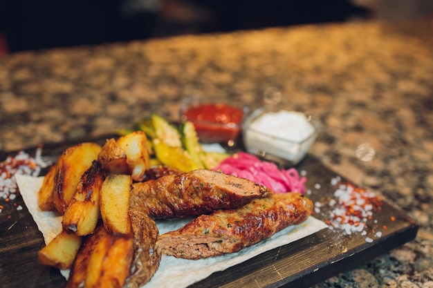 Seiki grillé sur une planche de bois avec sauce aux pommes de terre et légumes