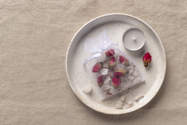 Sel de bain fait à la main avec des roses séchées et des herbes dans un sac en filet