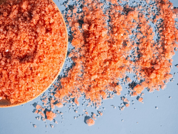 Sel de bain orange dans un fond bleu de soucoupe avec une ombre d'une plante tropicale. Copyspace, flatlay. Spa, détendu, été