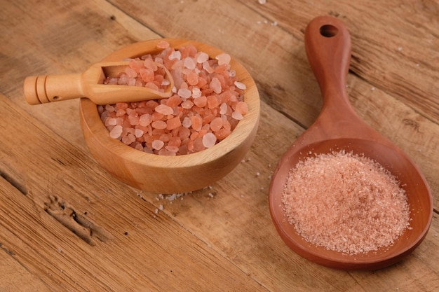 Sel de cristal rose de l'Himalaya dans un bol en bois. Contient des minéraux fer, soufre, magnésium, calcium.