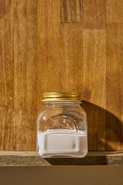 Photo sel de table dans un bocal vintage sur une étagère de cuisine en bois.