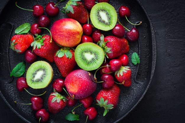 Sélection. de baies d&#39;été et de fruits sur une plaque noire.